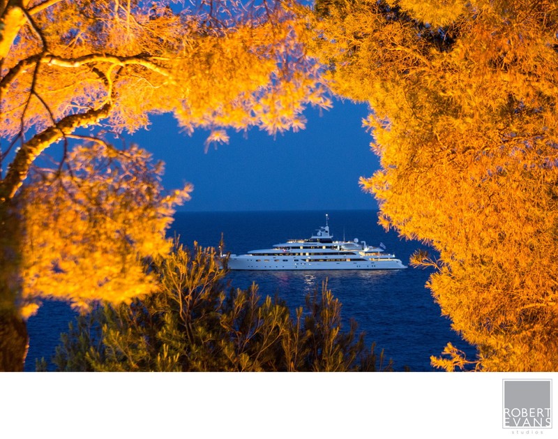 Luxury yacht framed by golden trees at a destination wedding in Saint-Jean-Cap-Ferrat, France