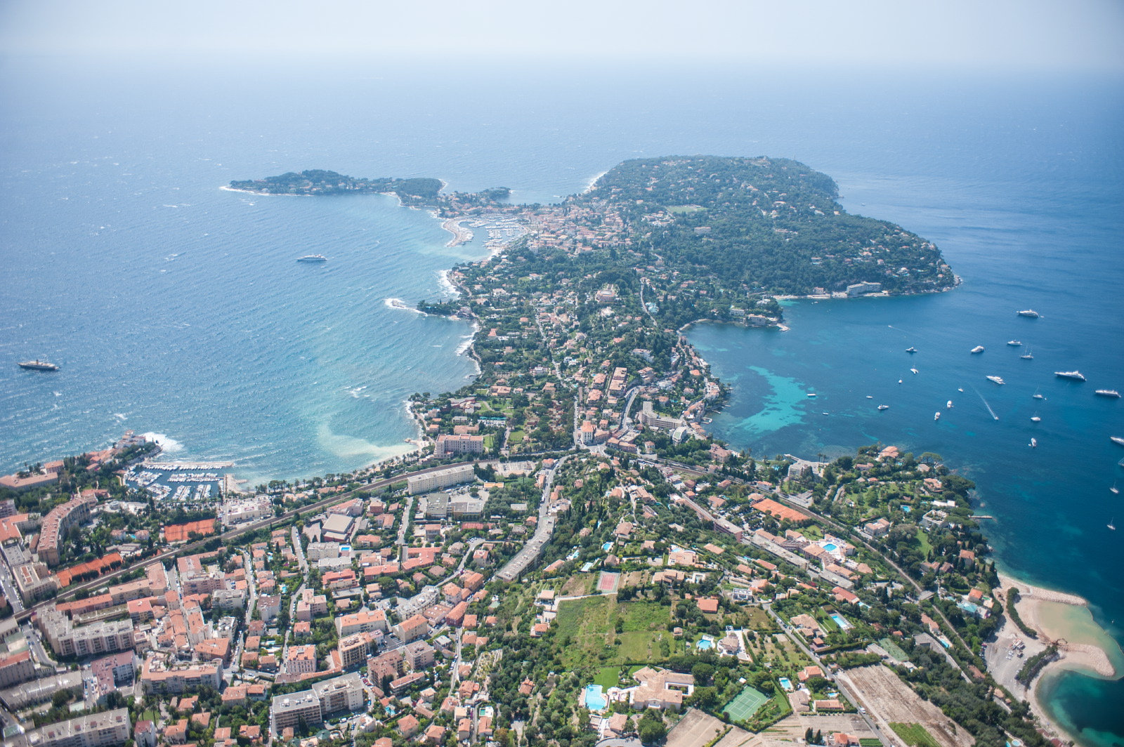 A sweeping aerial view of Saint-Jean-Cap-Ferrat surrounded by blue Mediterranean water